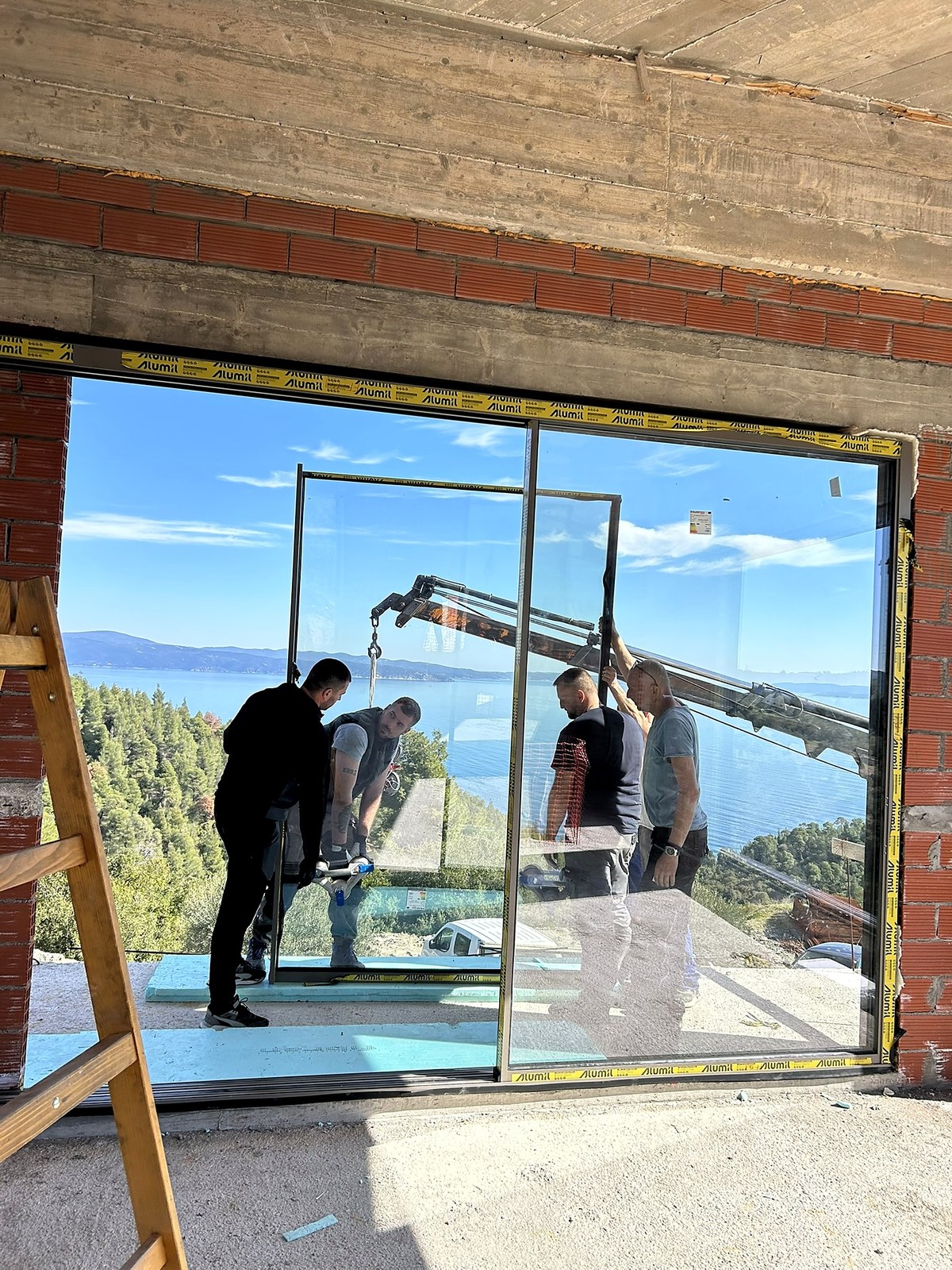 Akra Vista villa under construction — glazing day — the sliding sea-walls go in