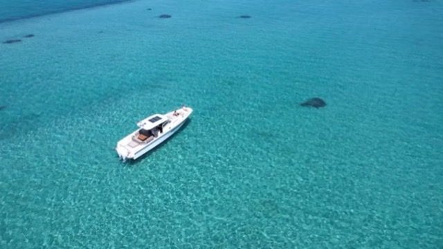 The T11 anchored alone over pale turquoise shallows off Sithonia